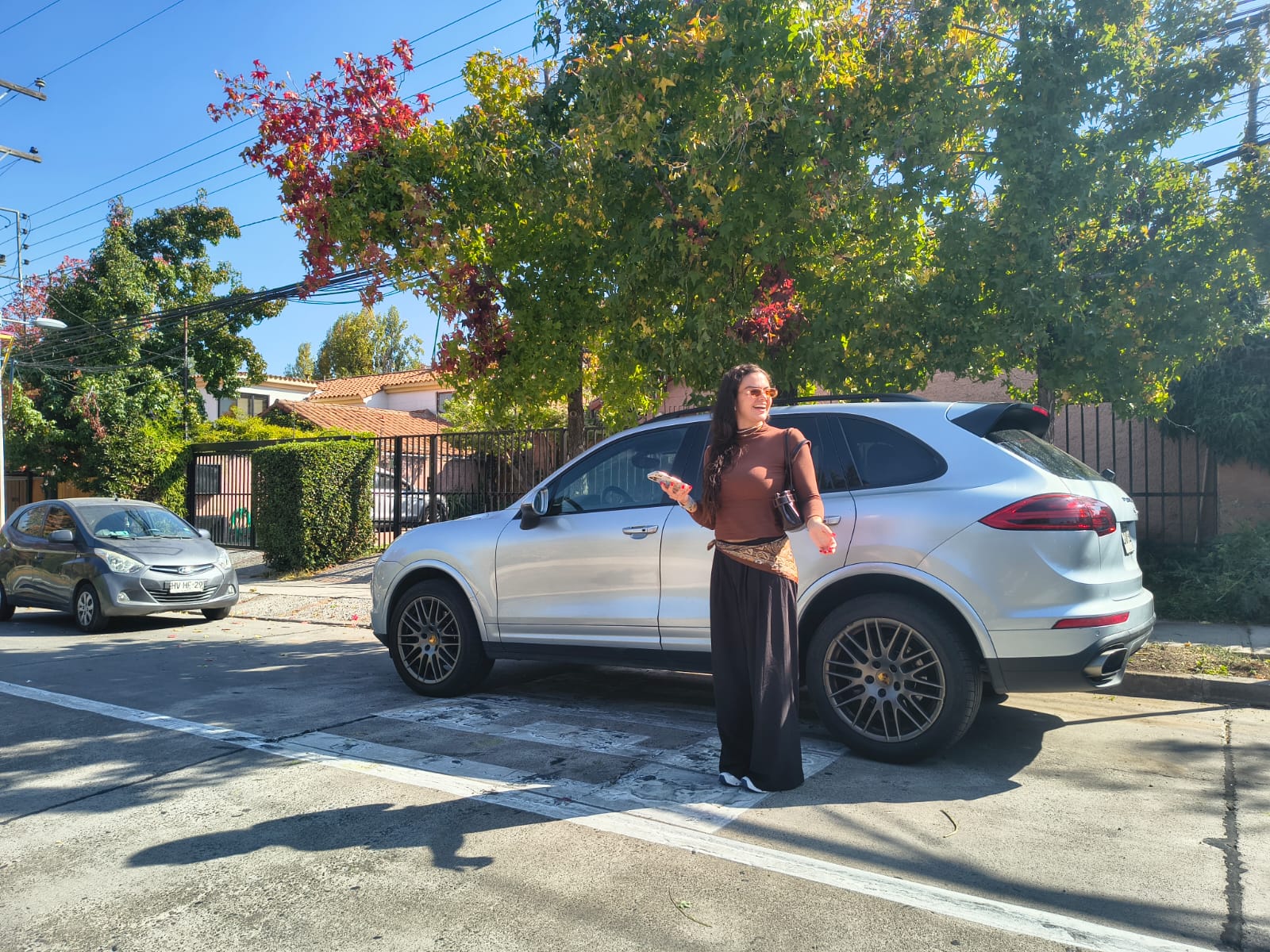 Carolina y el Porsche Cayenne en una calle del barrio El Golf con árboles de otoño