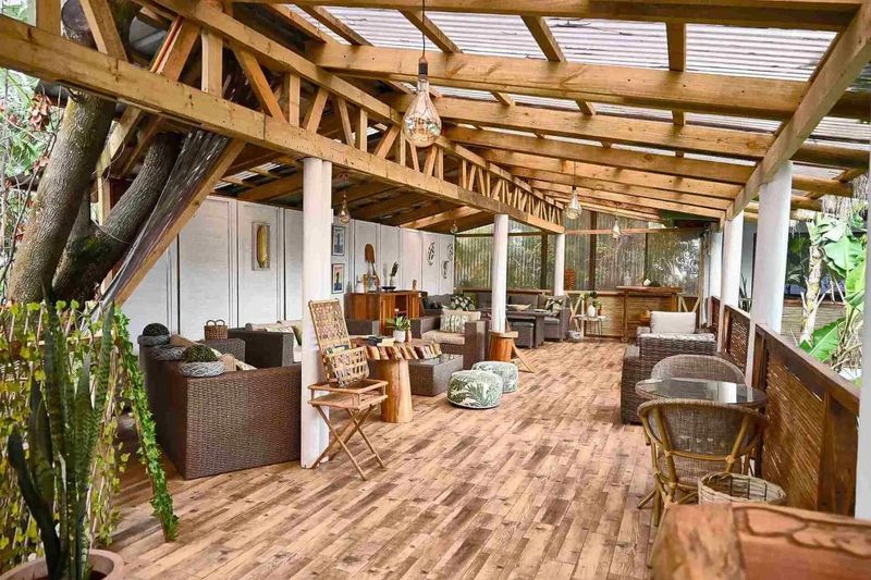 Terraza techada de madera del hotel Hare Nua, con sillones y plantas.
